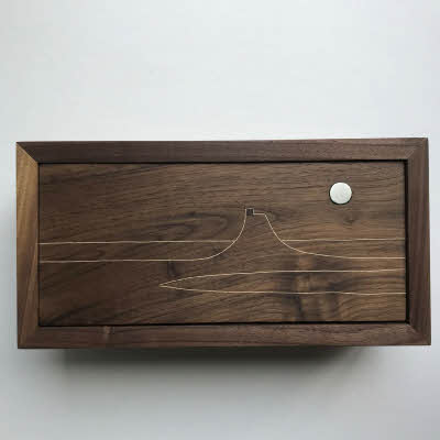 This American Black Walnut tipper jewelry box has an inlayed design of Lindesfarne and a pewter moon on the lid.