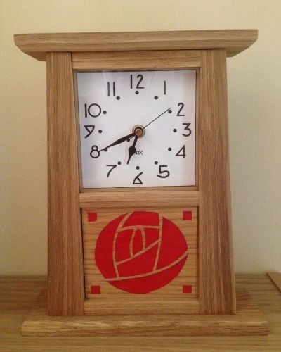 This is an Arts and Crafts style mantle clock with a Mackintosh rose design in the bottom panel.