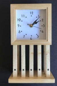 This Mackintosh inspired mantle clock has nine individually cut legs. It is made in ash with rosewood decoration and a Mackintosh font face.