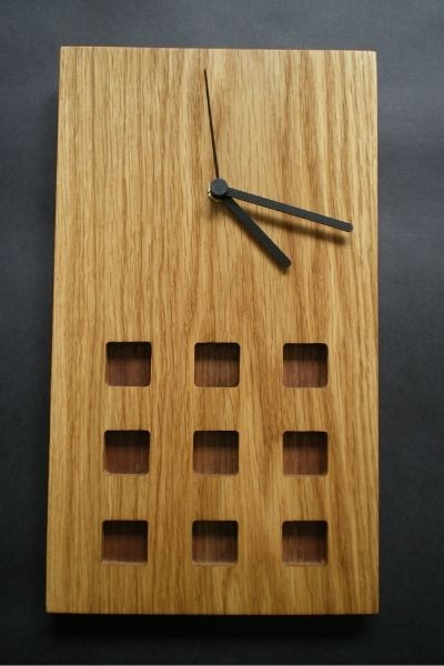A small Mackintosh inspired oak wall clock with a latticework design and a teak contrasting panel.