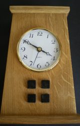 This oak Arts and Crafts style mantle clock has rosewood squares and a white Arabic insert