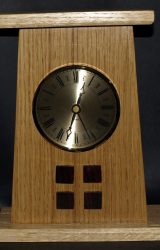 This version of the Arts and Crafts mantle clock has four rosewood squares and an insert face of gold with Roman numerals.