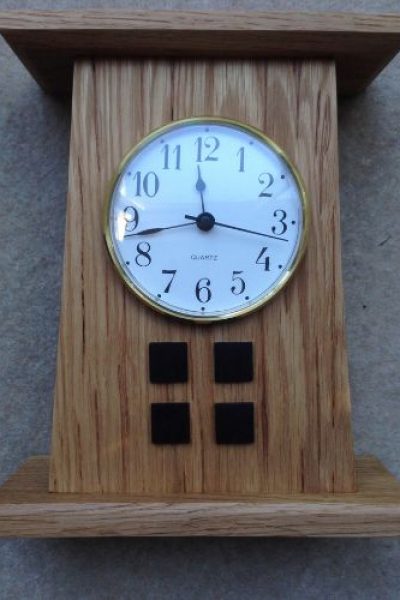 This small mantle clock has in insert face and features four rosewood squares in the Mackintosh style.